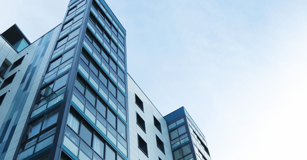 Low-angle view of a modern glass skyscraper against a clear sky in Poole, UK.